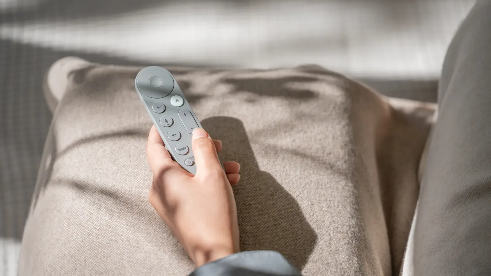 使用者手持 Google TV Streamer 遙控器的 Google 官方情境照片